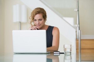 Pretty mid-adult woman using laptop in her office